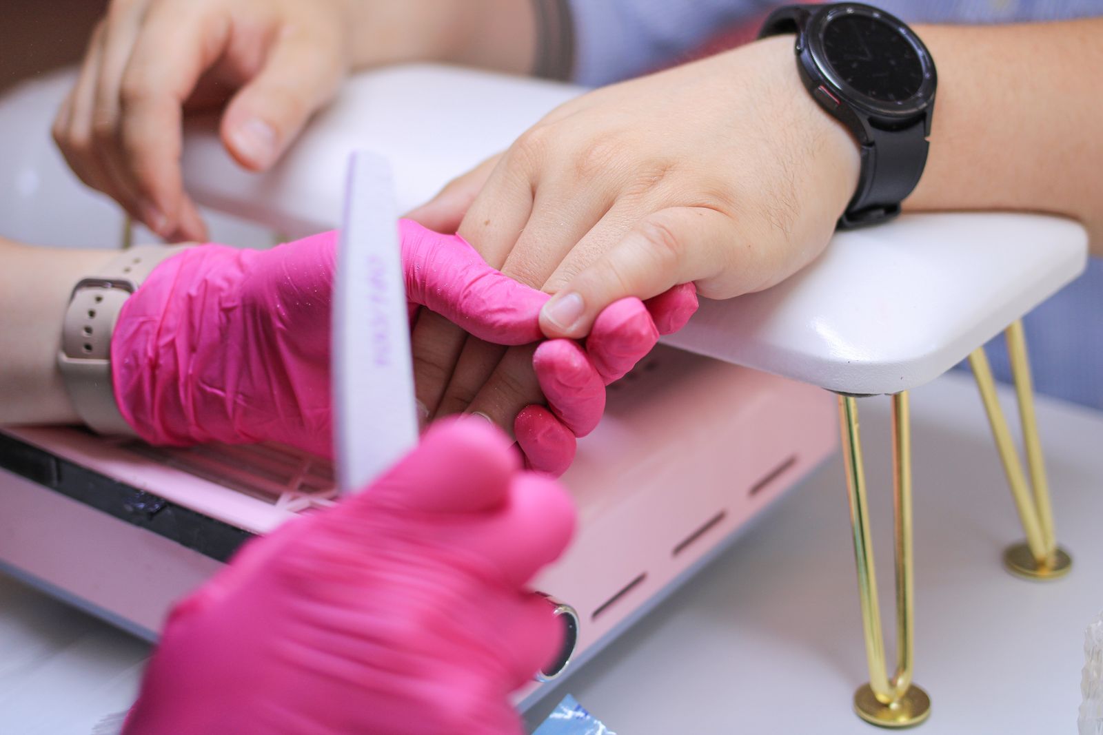 Nail technician preparing nails for builder gel