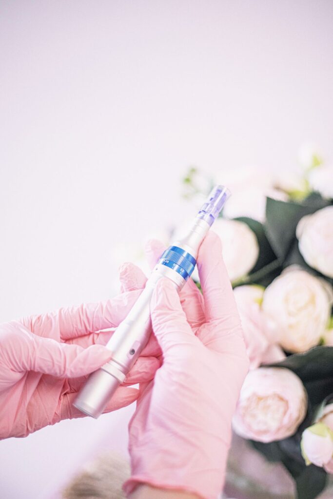 Microneedling pen held by a gloved practitioner