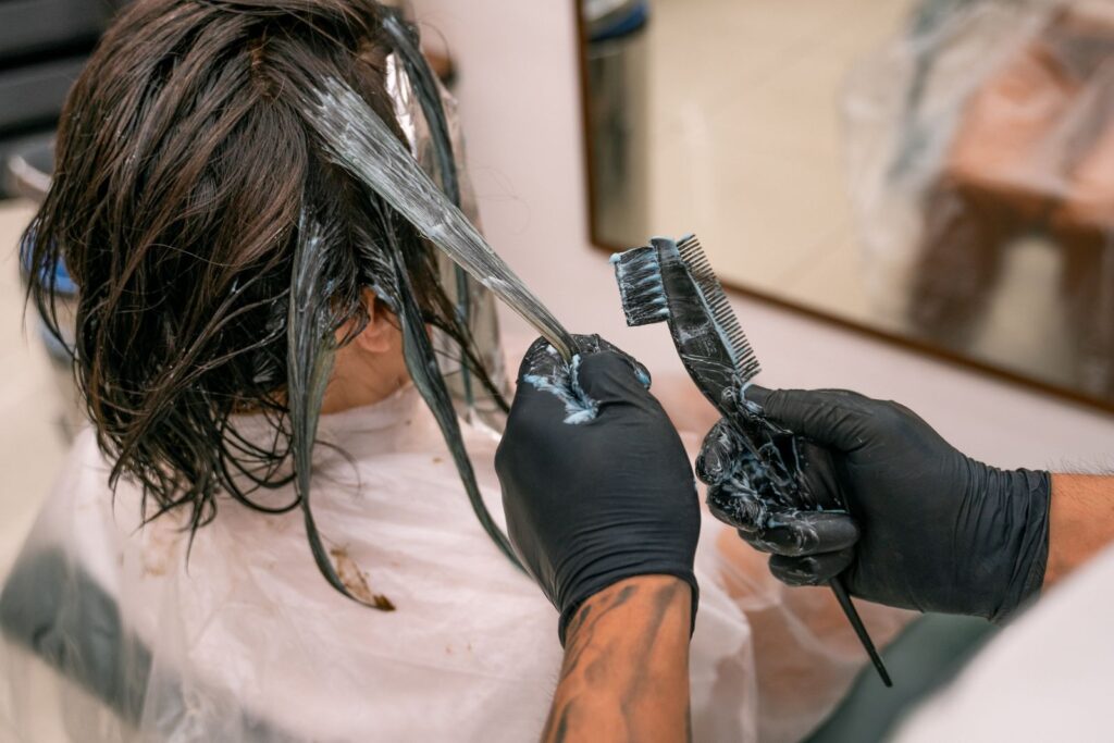 Hairdresser applying colour to a client's hair